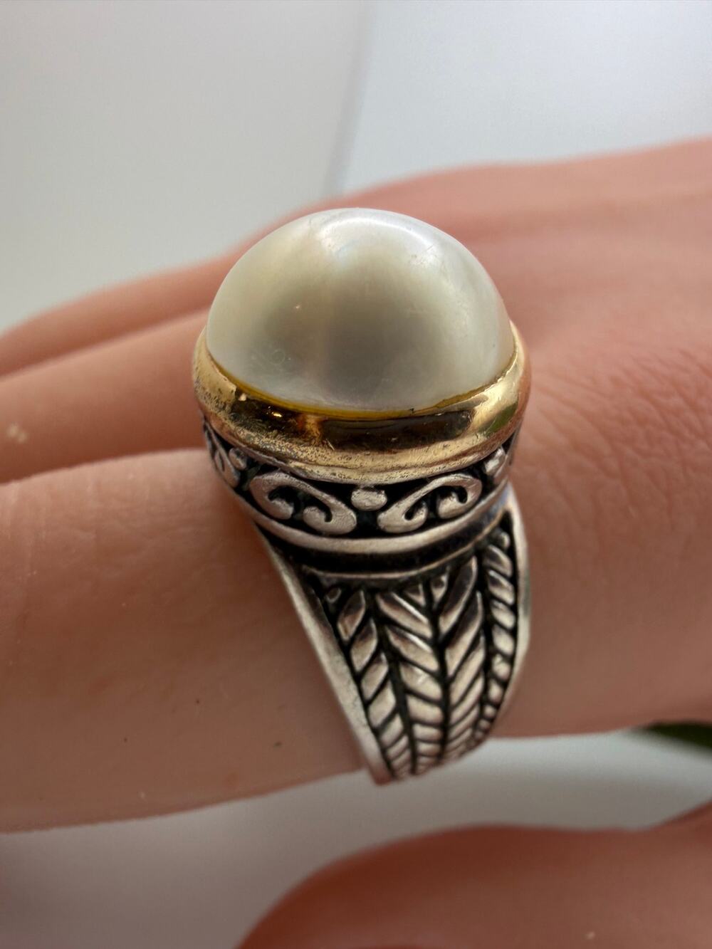 white pearl crowned on an oxidized sterling silver band yellow gold accents